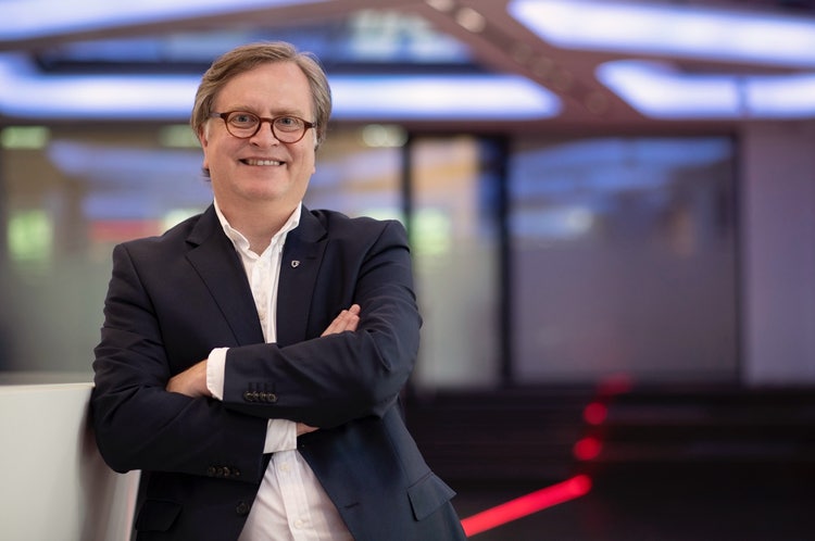 Ein Bild, das Kleidung, Person, Menschliches Gesicht, Lächeln enthält. Automatisch generierte Beschreibung