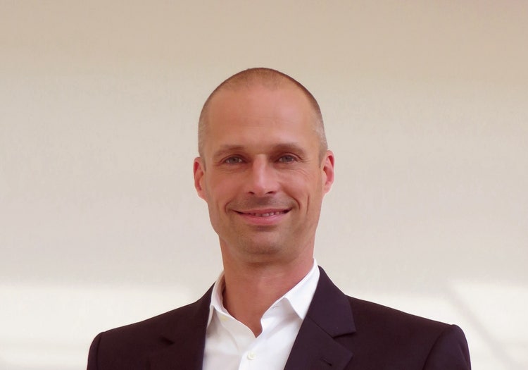 Ein Bild, das Menschliches Gesicht, Person, Kleidung, Lächeln enthält. Automatisch generierte Beschreibung