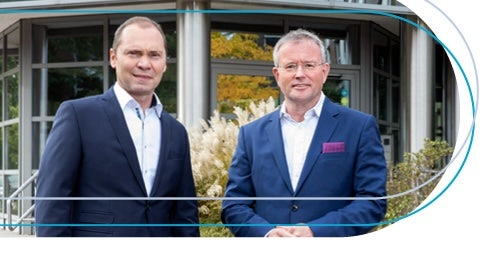 Ein Bild, das Person, Anzug, Kleidung, Lächeln enthält. Automatisch generierte Beschreibung