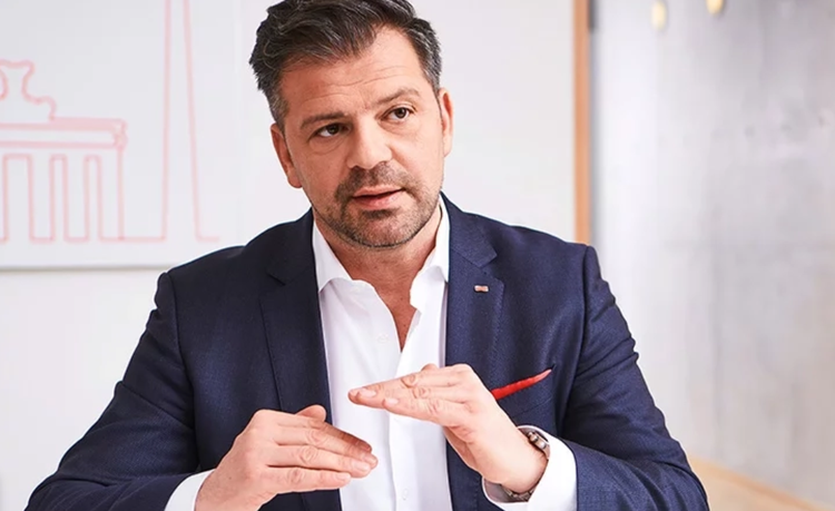 Ein Bild, das Kleidung, Menschliches Gesicht, Person, Mann enthält. Automatisch generierte Beschreibung