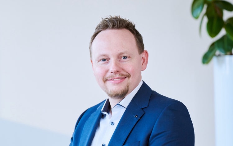 Ein Bild, das Menschliches Gesicht, Person, Formelle Kleidung, Lächeln enthält. KI-generierte Inhalte können fehlerhaft sein.