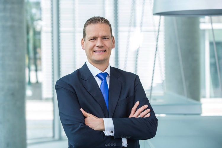Ein Bild, das Person, Menschliches Gesicht, Formelle Kleidung, Lächeln enthält. KI-generierte Inhalte können fehlerhaft sein.